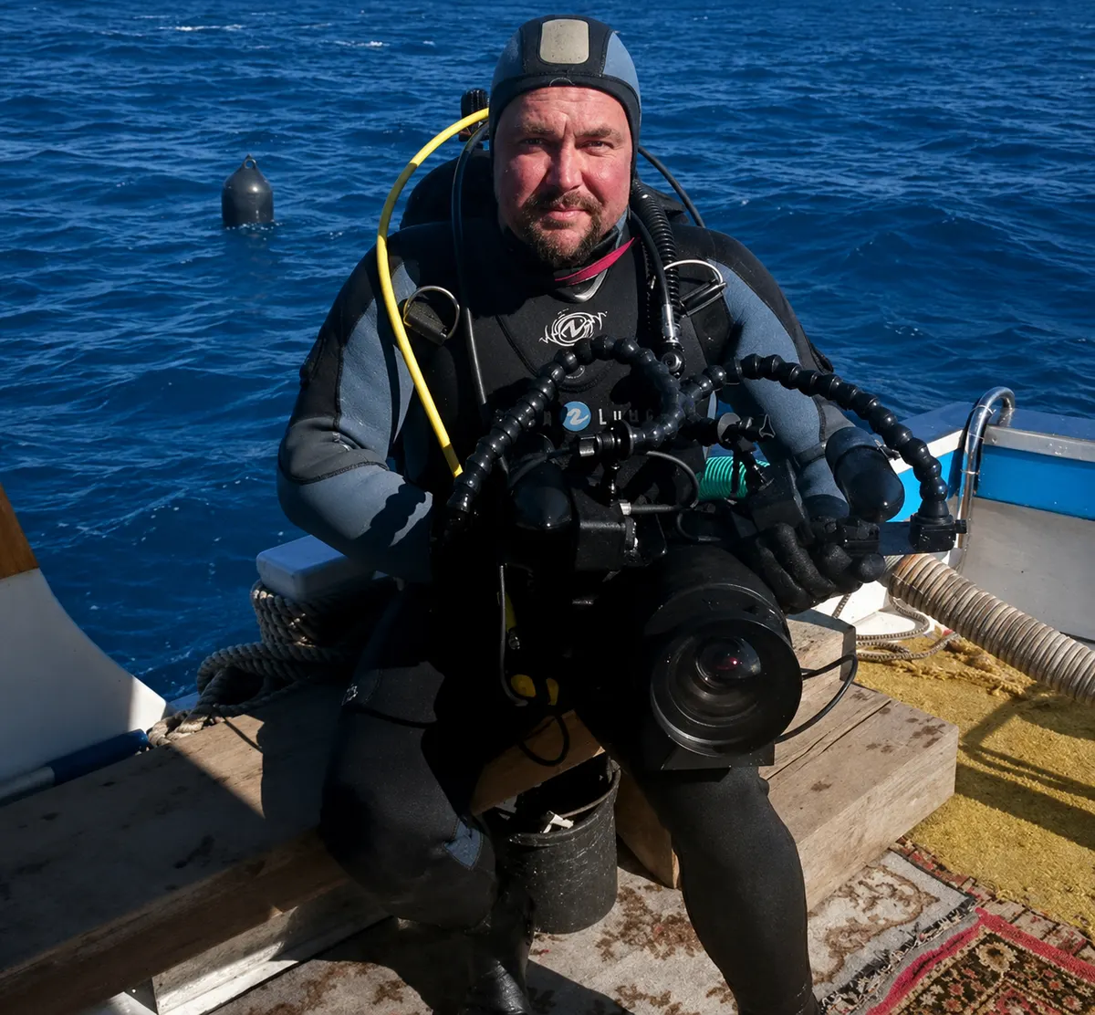 Diver with an underwater camera on a boat